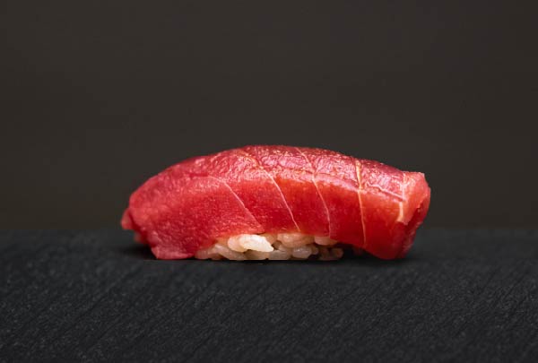 黒い皿に載せられた艶やかなまぐろの握り寿司