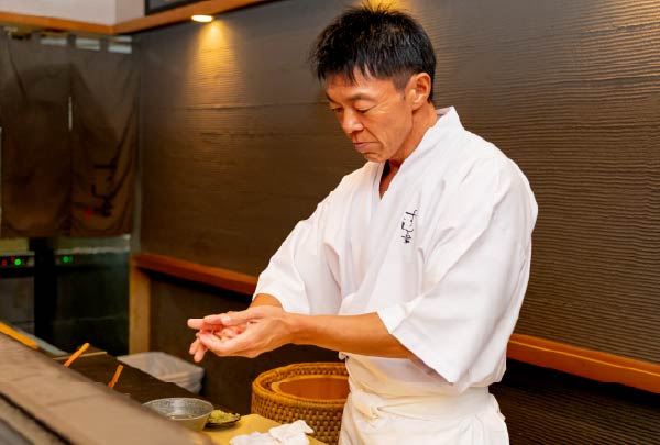 真剣な表情で寿司を握るすし家の店主