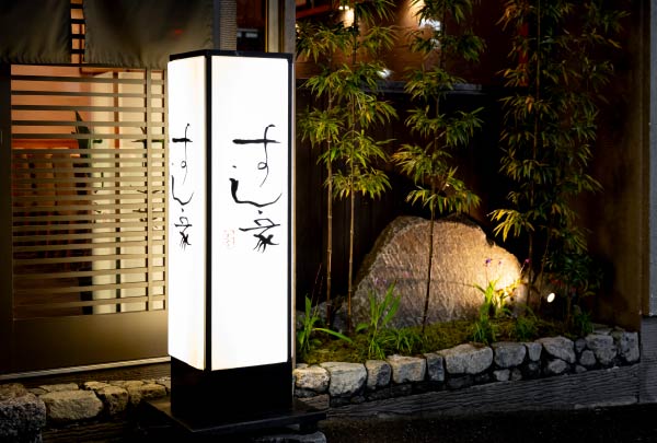 夜間にライトアップされた『すし家』の看板と風情ある店舗外観