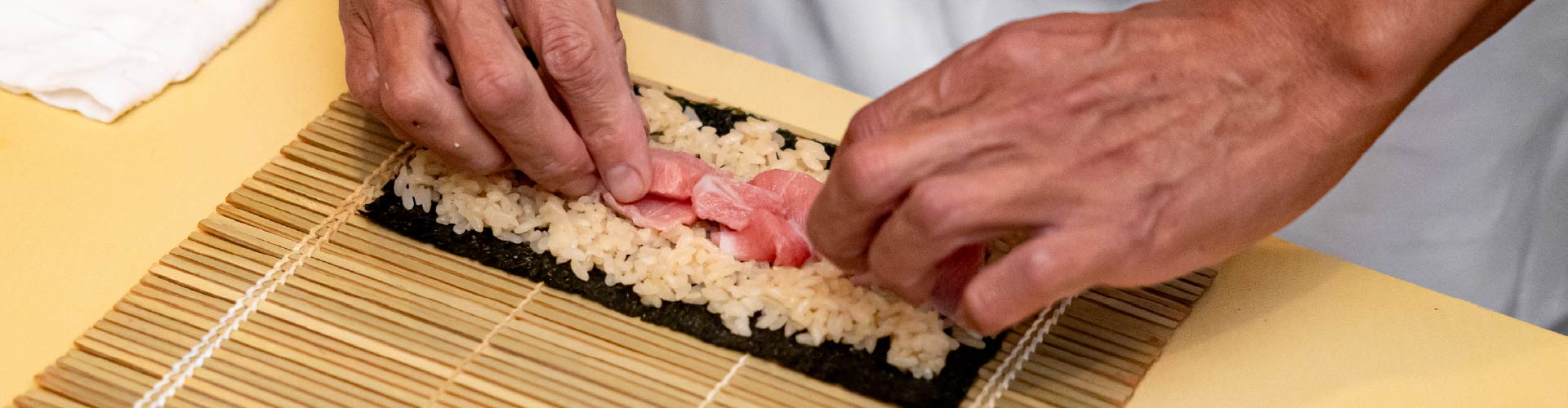 巻き簾を使って巻き寿司を仕上げる職人の手元