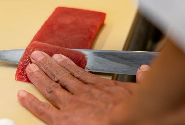 包丁でマグロを切り分ける職人の手元