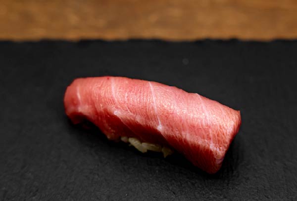 黒い皿に載せられた艶やかなマグロの握り寿司